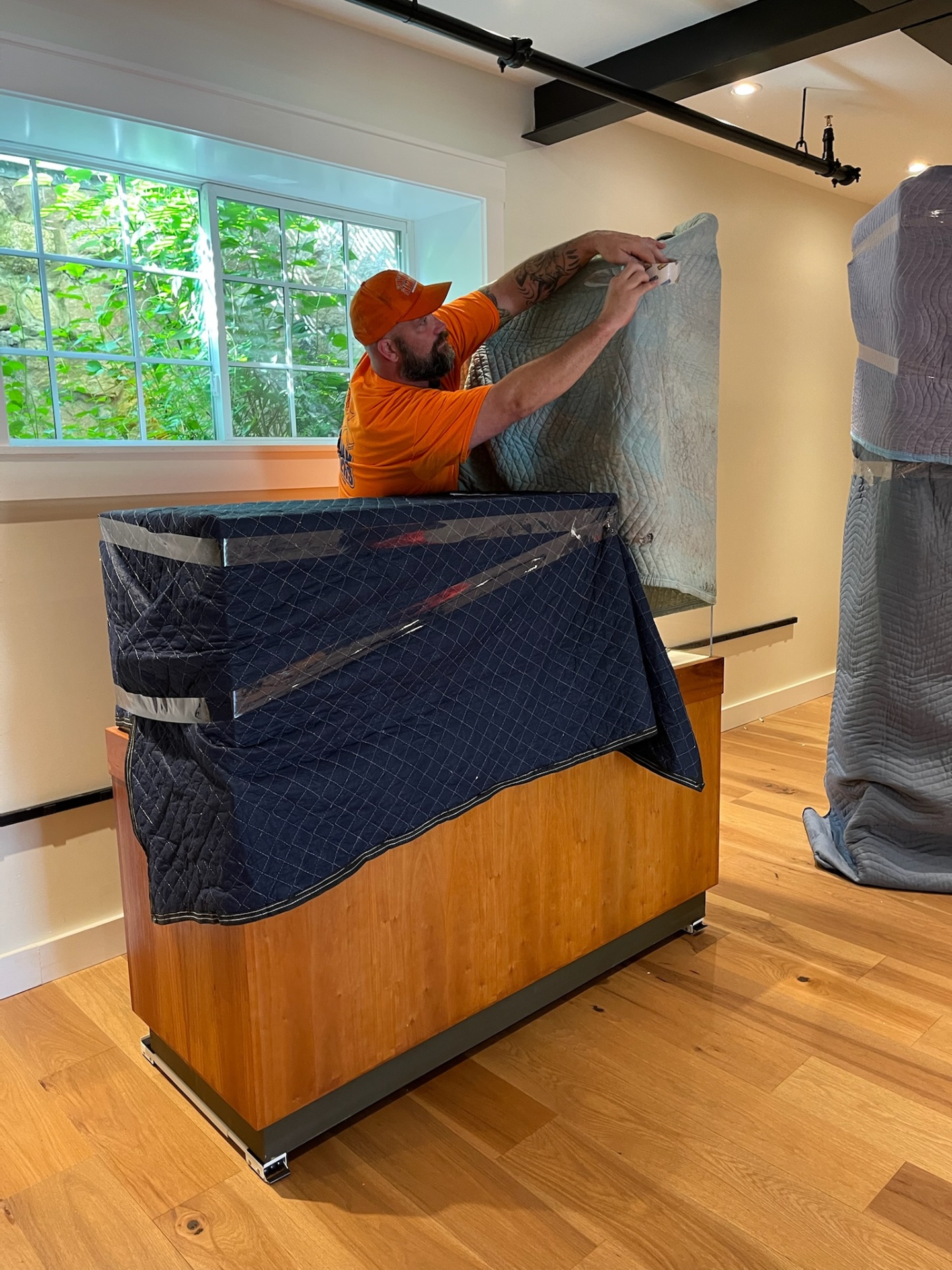 Crew member carefully wrapping furniture for a piano move